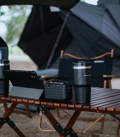 Camp table with gear under an awning